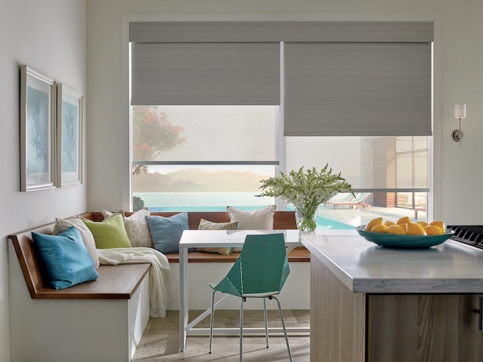 A kitchen with bright turquoise pillows and bowl.